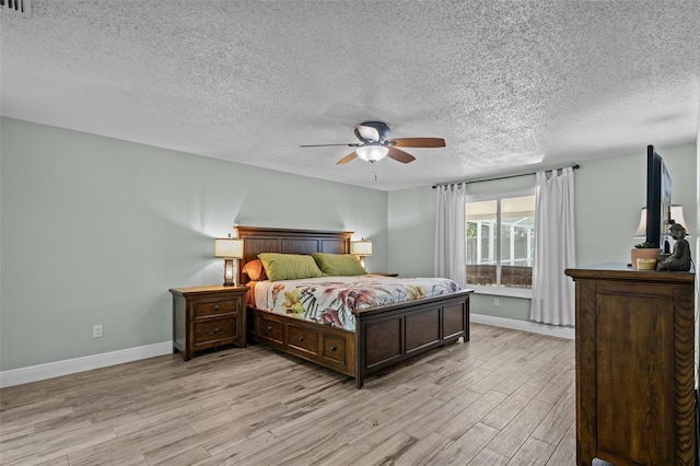 bedroom with ceiling fan, a textured ceiling, and light hardwood / wood-style flooring