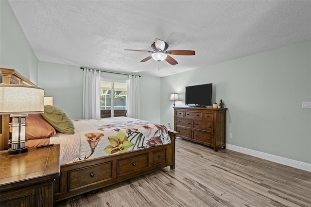 bedroom with access to exterior, ceiling fan, a textured ceiling, and light wood-type flooring