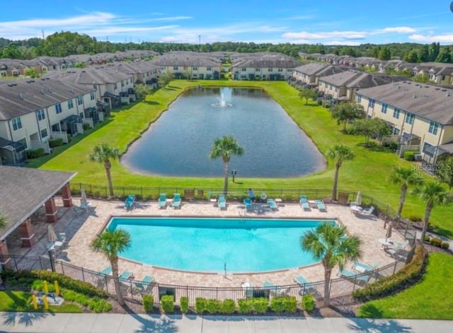 view of swimming pool featuring a lawn and a water view