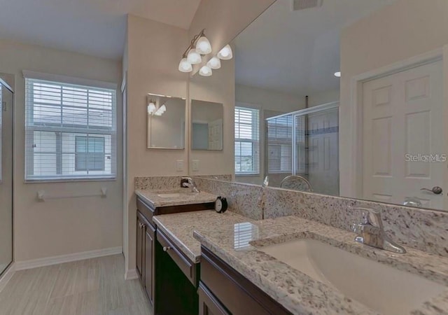 bathroom with vanity and a shower with door