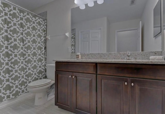 bathroom with tile patterned flooring, vanity, and toilet