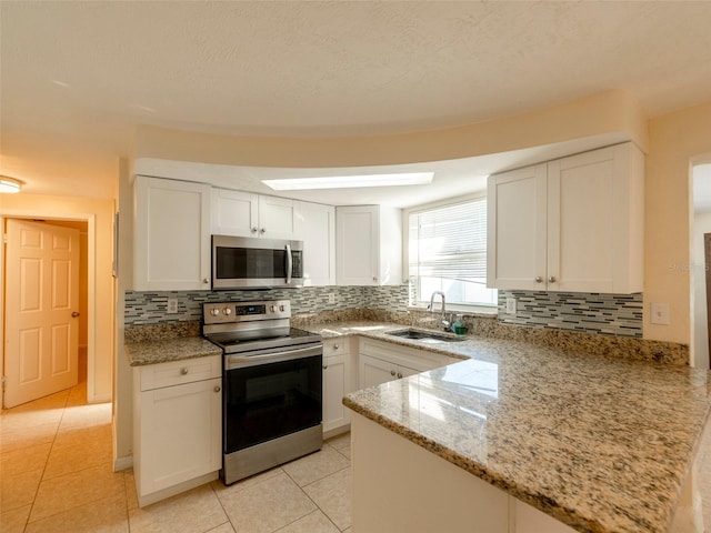 kitchen featuring white cabinets, sink, kitchen peninsula, and stainless steel appliances