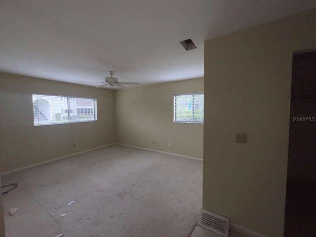 spare room with ceiling fan and light colored carpet