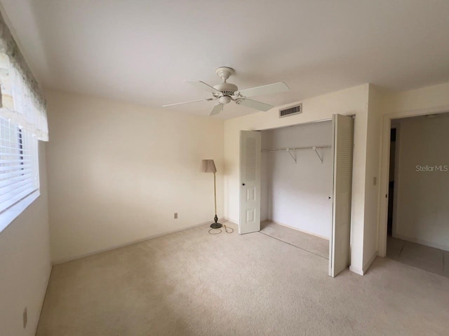 unfurnished bedroom with a closet, ceiling fan, and light colored carpet