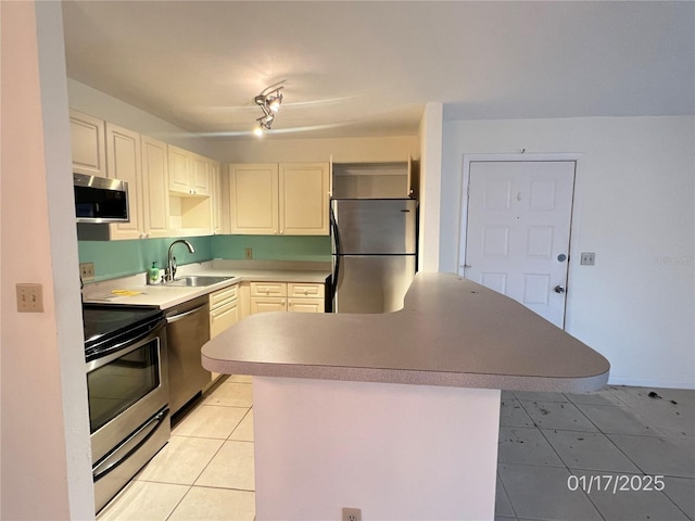 kitchen featuring sink, light tile patterned floors, white cabinets, and appliances with stainless steel finishes