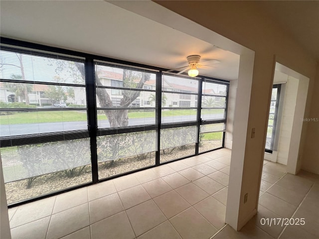 unfurnished sunroom with ceiling fan