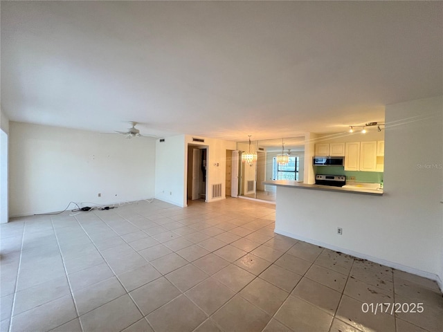 unfurnished living room featuring ceiling fan with notable chandelier and light tile patterned floors