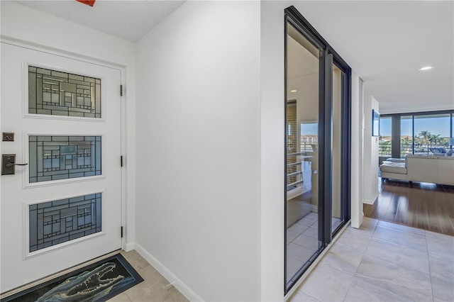 interior space featuring a wall of windows and light tile patterned floors