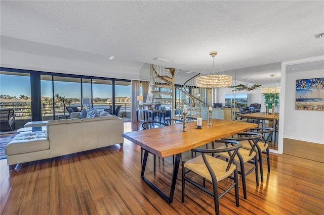 dining area with a textured ceiling, a chandelier, and hardwood / wood-style flooring