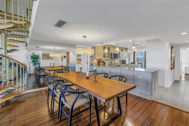 dining room featuring a textured ceiling, a notable chandelier, and dark wood-type flooring