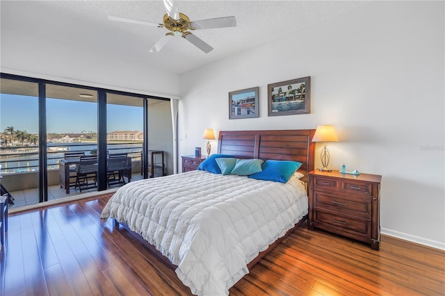 bedroom with dark wood-type flooring, a textured ceiling, ceiling fan, and access to exterior