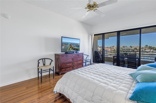 bedroom featuring ceiling fan, dark wood-type flooring, access to outside, and a textured ceiling