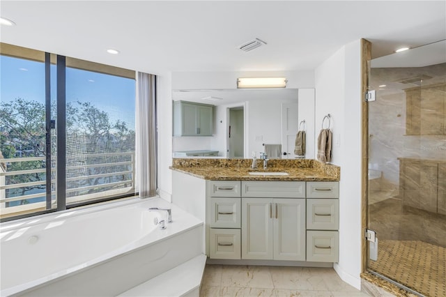 bathroom with vanity and independent shower and bath