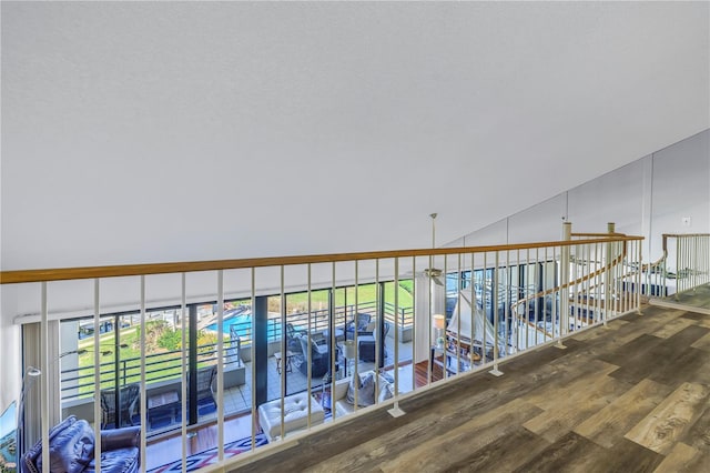 corridor with vaulted ceiling and hardwood / wood-style floors