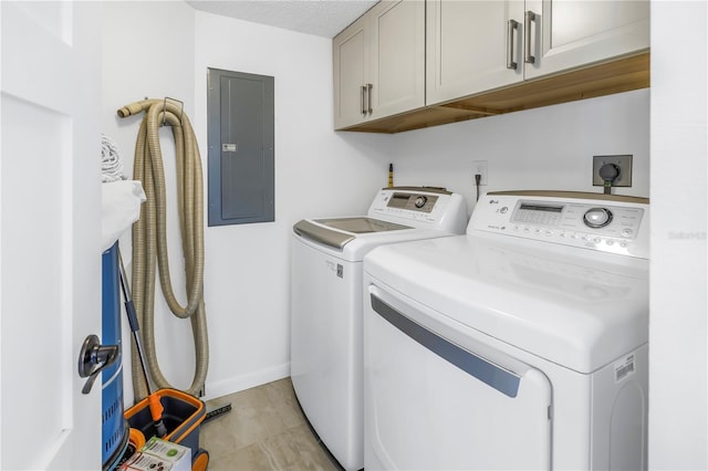 clothes washing area featuring electric panel, cabinets, and independent washer and dryer