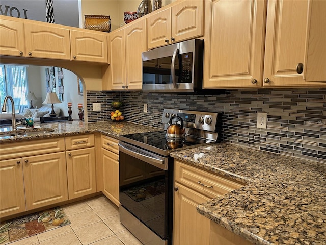 kitchen with appliances with stainless steel finishes, light brown cabinetry, sink, and light tile patterned floors