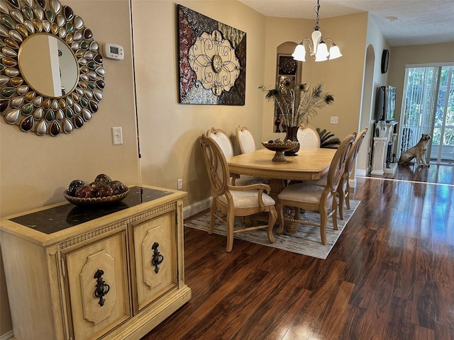 dining space featuring dark hardwood / wood-style floors and a chandelier