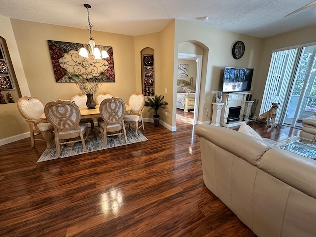 dining space featuring an inviting chandelier, dark hardwood / wood-style floors, and a textured ceiling