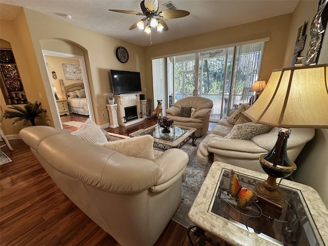 living room featuring ceiling fan and dark hardwood / wood-style flooring