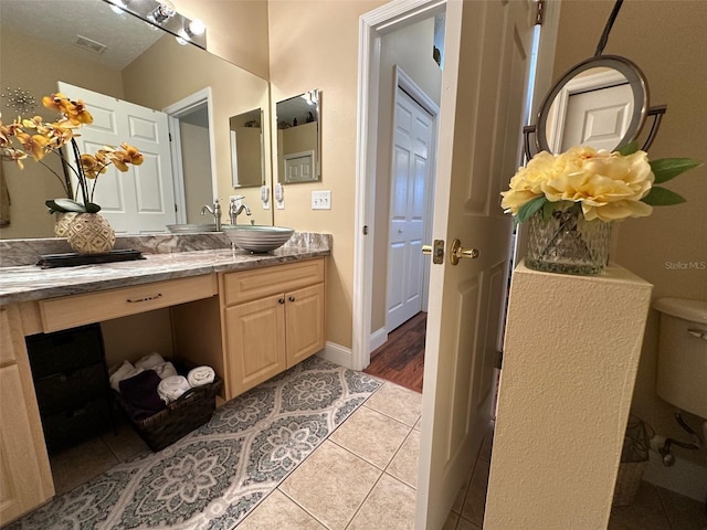 bathroom featuring vanity, tile patterned floors, and toilet