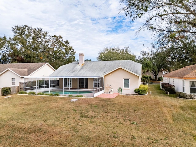 rear view of house featuring a patio area, a sunroom, and a lawn