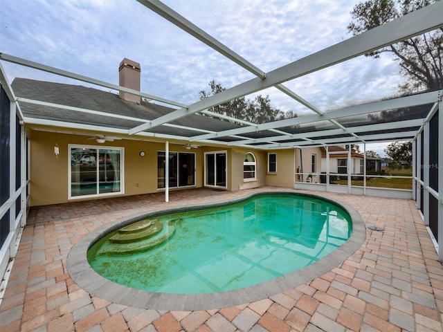 view of swimming pool featuring a patio area, a lanai, and ceiling fan