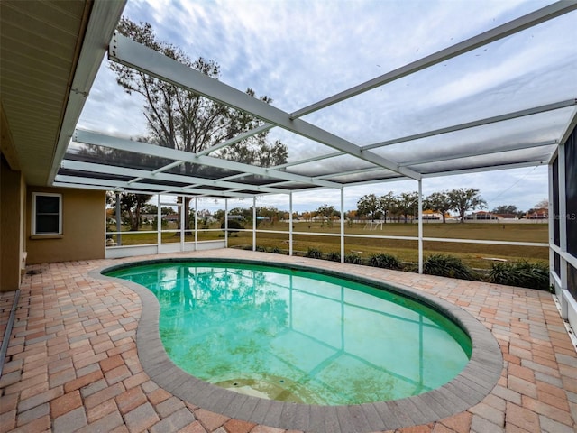 view of swimming pool featuring a patio area and a lanai