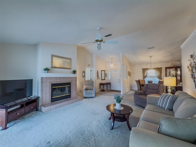 carpeted living room featuring ceiling fan, lofted ceiling, and a tiled fireplace