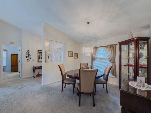 carpeted dining room featuring vaulted ceiling and a notable chandelier