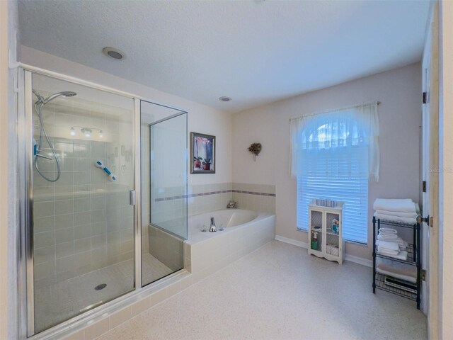 bathroom featuring a textured ceiling and separate shower and tub