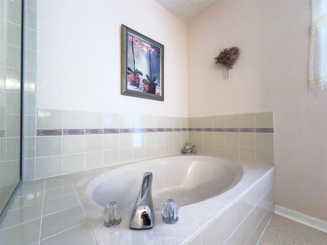 bathroom featuring tile patterned flooring and a relaxing tiled tub