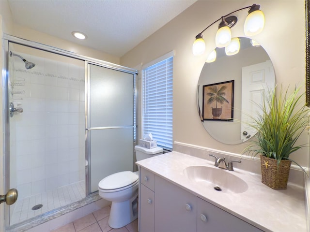 bathroom with tile patterned floors, toilet, a shower with door, and vanity