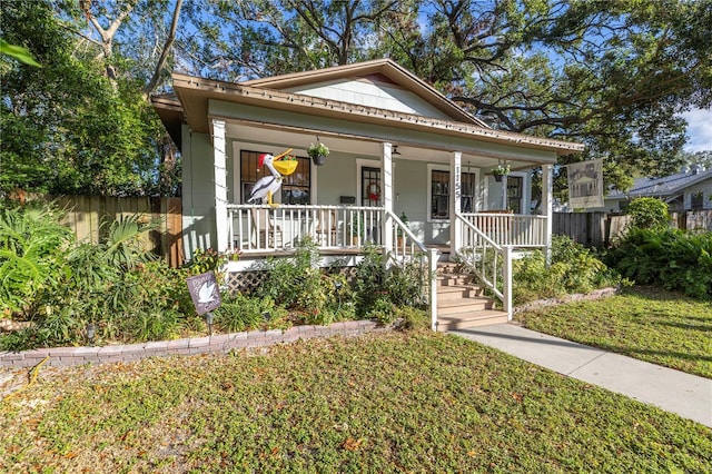 bungalow with covered porch and a front yard