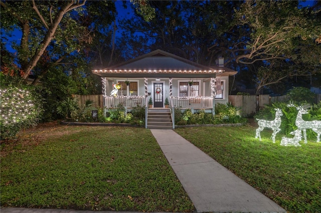 bungalow-style house with covered porch and a lawn