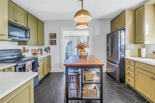 kitchen with light stone countertops, french doors, hanging light fixtures, stainless steel appliances, and green cabinetry