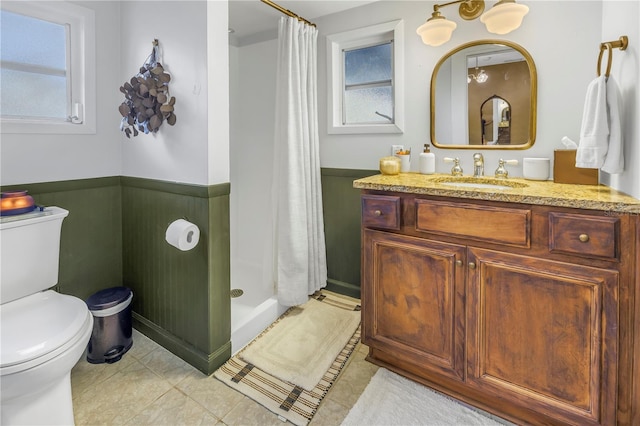 bathroom featuring curtained shower, tile patterned floors, toilet, wooden walls, and vanity