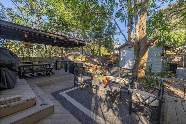 wooden deck with a storage shed and a grill