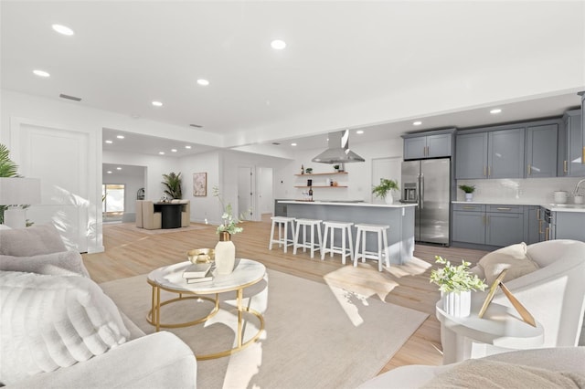 living room with light hardwood / wood-style floors and sink