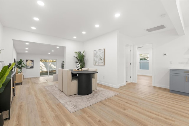 interior space featuring gray cabinetry, a breakfast bar, and light hardwood / wood-style floors