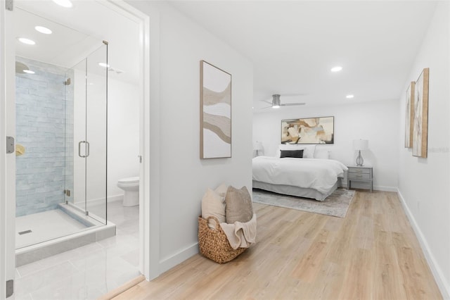 bedroom with ceiling fan, wood-type flooring, and ensuite bath