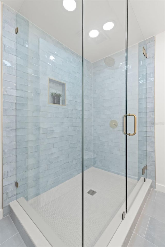 bathroom featuring tile patterned floors and a shower with shower door