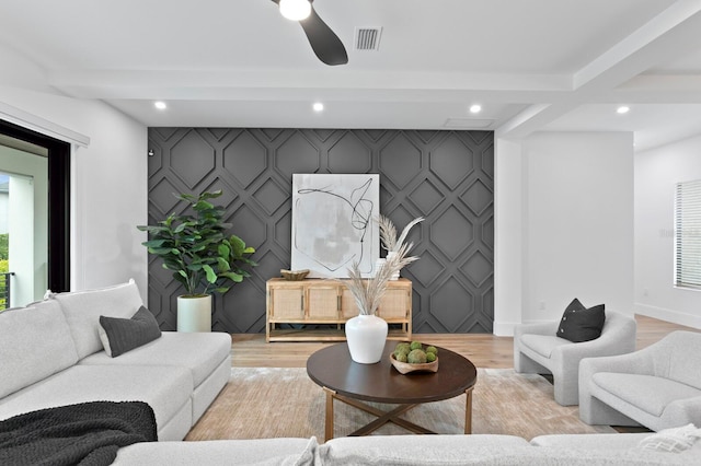 living room featuring beamed ceiling, ceiling fan, and light wood-type flooring