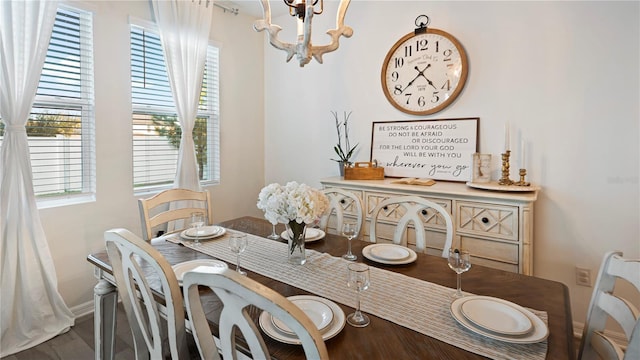 dining space with hardwood / wood-style flooring and an inviting chandelier