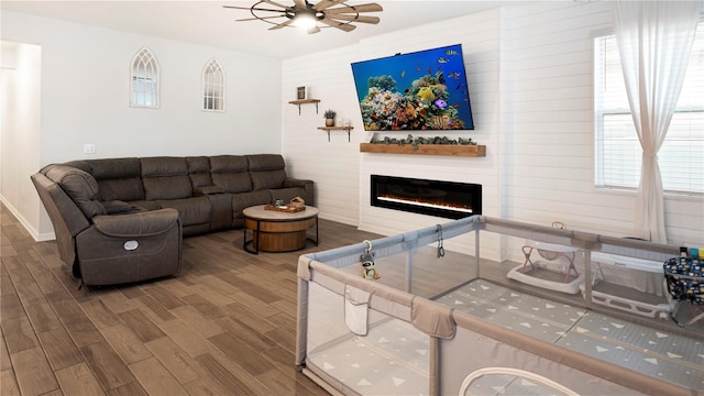 living room featuring a fireplace, hardwood / wood-style flooring, and ceiling fan