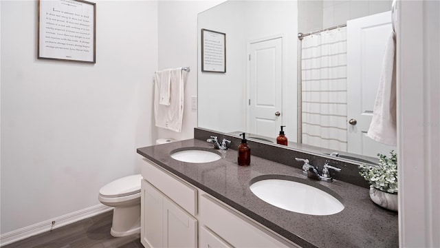 bathroom with hardwood / wood-style floors, vanity, and toilet