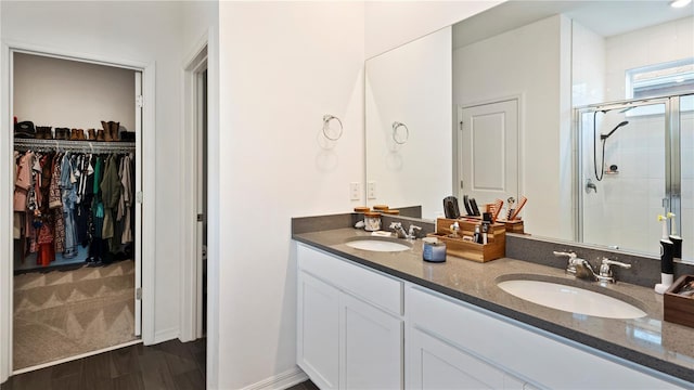 bathroom with hardwood / wood-style floors, vanity, and walk in shower