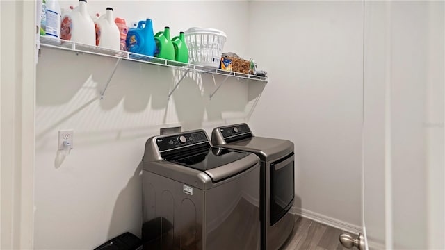 laundry area with hardwood / wood-style floors and washing machine and dryer