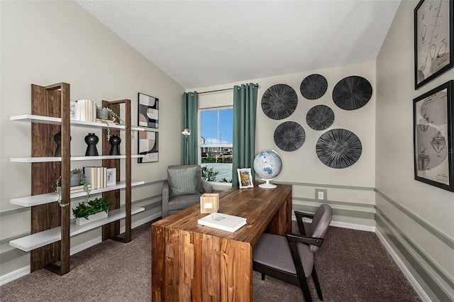 carpeted home office with a textured ceiling and vaulted ceiling