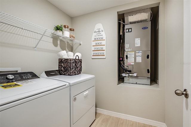 laundry area with heating unit and washer and clothes dryer