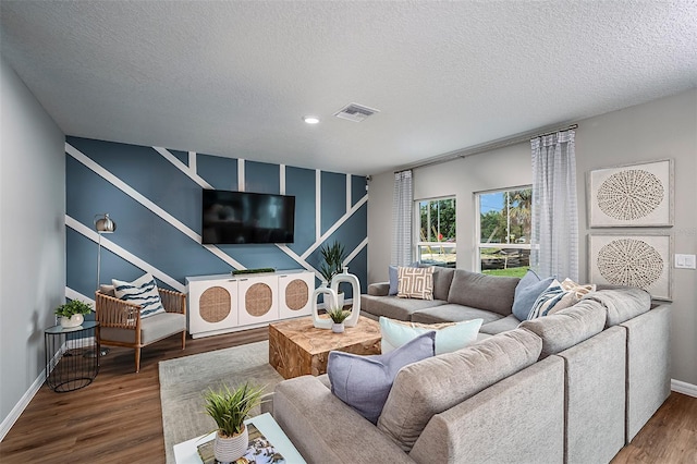 living room with wood-type flooring and a textured ceiling